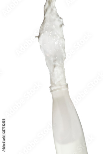 Milk Stream Pouring Out Of The Bottle. Isolated Over White Background.