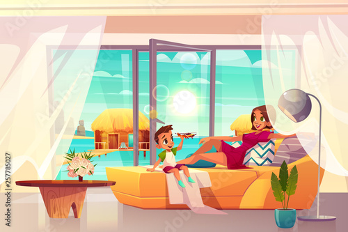 Relaxing in luxury resort hotel room cartoon vector. Happy young woman lying on sofa in comfortable apartments with exit on beach, son playing toy plane illustration. Family vacation travel in tropics