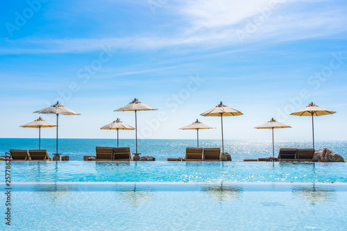 Beautiful landscape of sea ocean on sky with umbrella and chair around luxury outdoor swimming pool