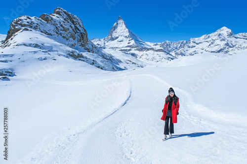 Young woman tourists in the snow with the Matterhorn Mountain background, Zermatt, Switzerland.