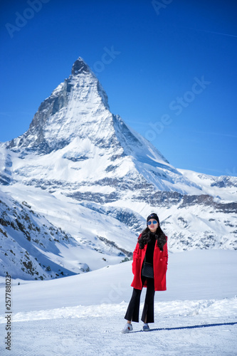 Young woman tourists in the snow with the Matterhorn Mountain background, Zermatt, Switzerland.