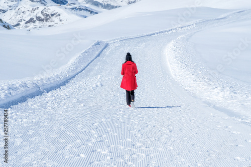 Young woman tourist walking in the snow, Zermatt, Switzerland.