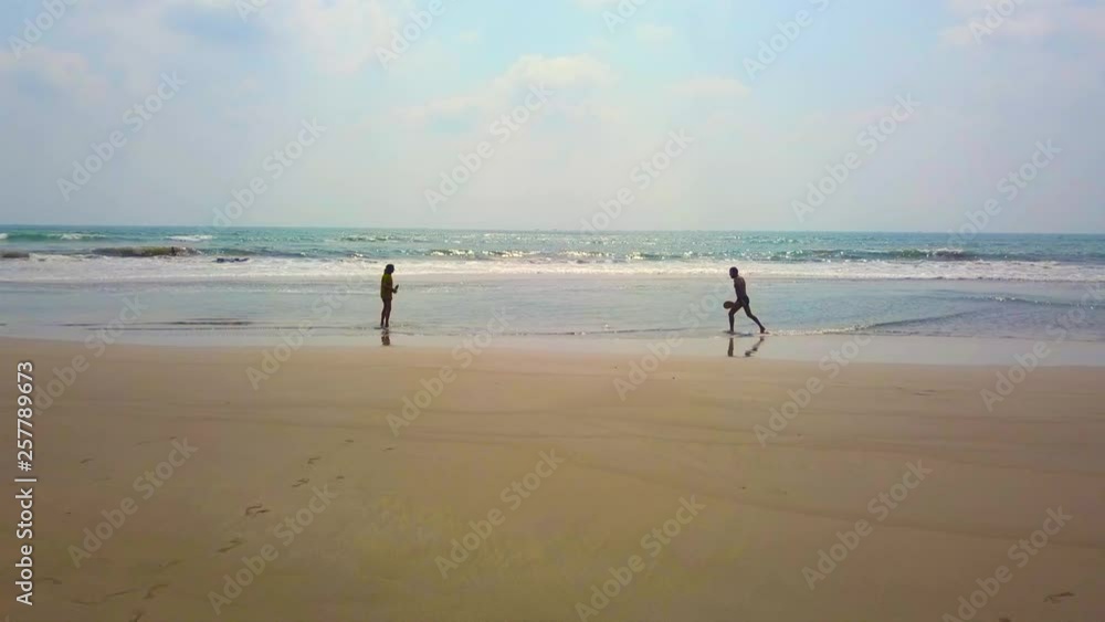 two middle aged people playing badminton on the beach at sunset. love, healthy life and relationships concept two middle aged people playing badminton on the beach at sunset. love, healthy life and relationships concept