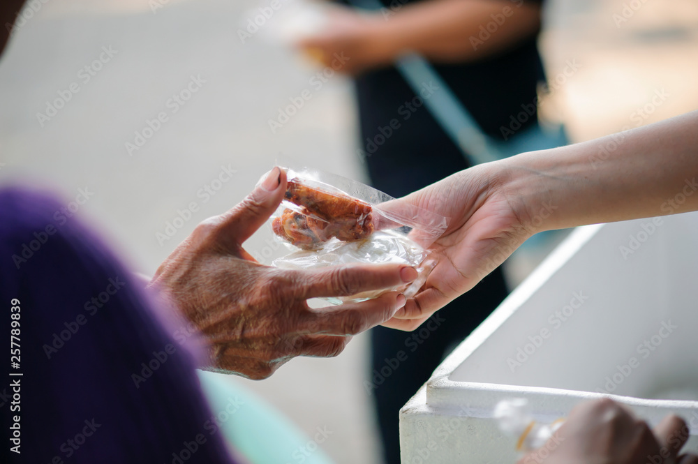 Obraz premium The hands of the rich are giving food to the poor and hungry.
