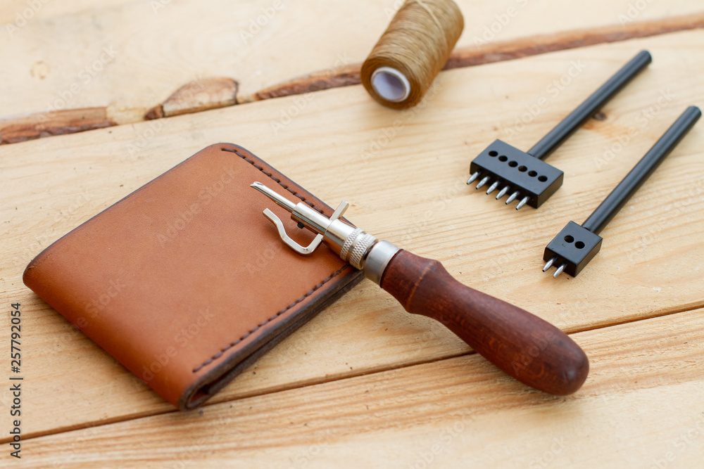 tools for leather work. wooden backgorund