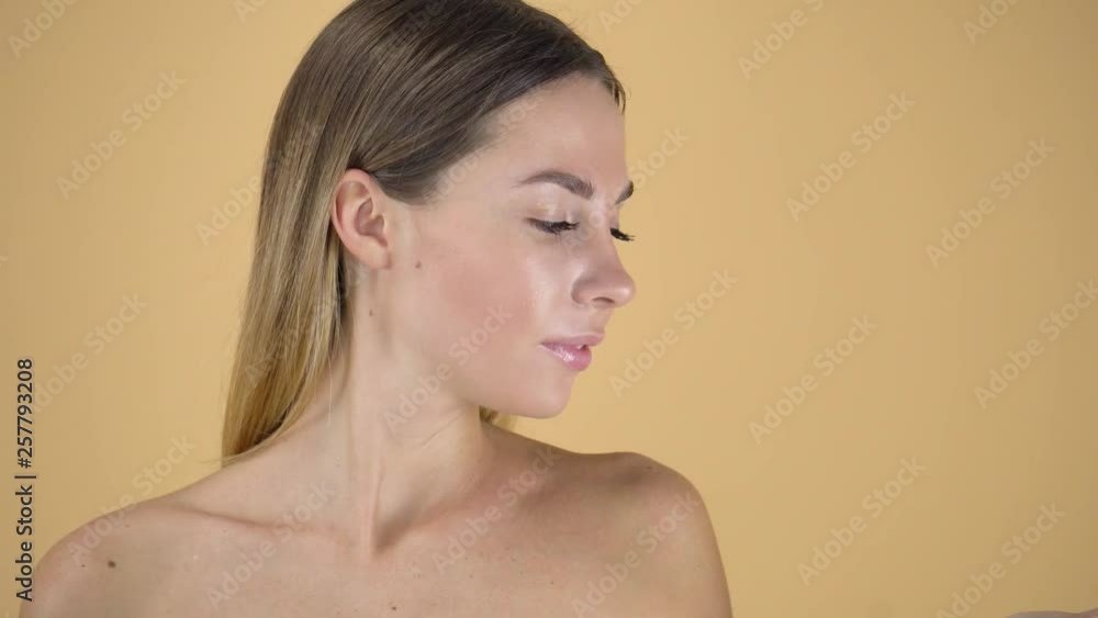 super model standing on coffee-colour backdrop, pretty girl with naked shoulders super model standing on coffee-colour backdrop, pretty girl with naked shoulders