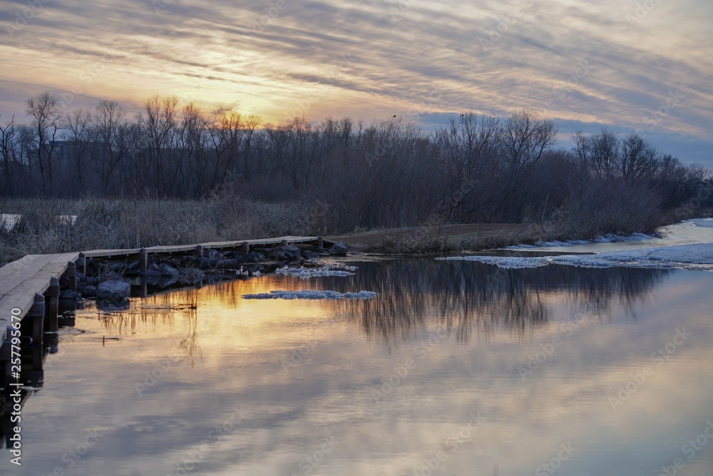 Footpath over a lake at sunset surrounded by woods Footpath over a lake at sunset surrounded by woods
