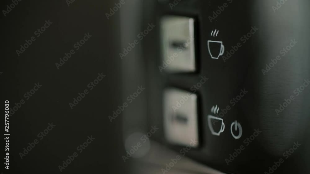 Extreme close up detail shot of male finger turning on coffee machine, blue light is flashing shows maintenance mode and waiting time for beverage preparation, 4K UHD Extreme close up detail shot of male finger turning on coffee machine, blue light is flashing shows maintenance mode and waiting time for beverage preparation, 4K UHD