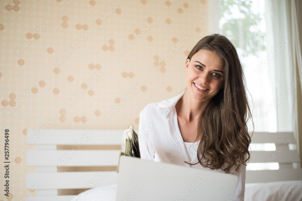 Happy Beautiful woman working on a laptop on the bed in the house Happy Beautiful woman working on a laptop on the bed in the house