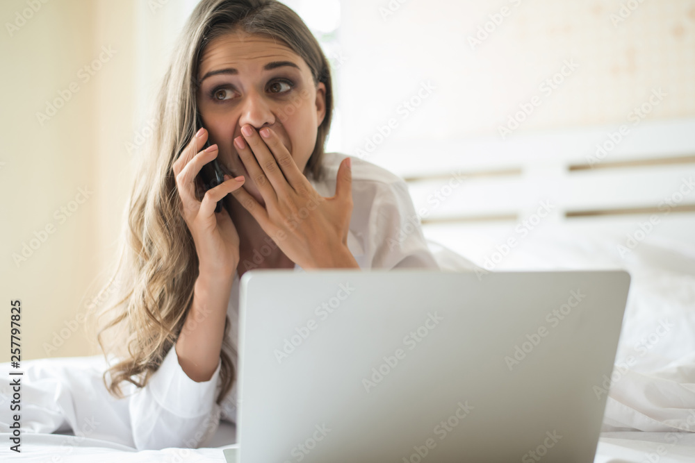 Happy Beautiful woman working on a laptop on the bed in the house Happy Beautiful woman working on a laptop on the bed in the house