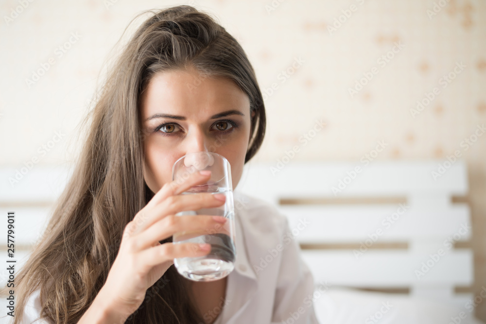 Beautiful woman drinking fresh water in the bed at the morning Beautiful woman drinking fresh water in the bed at the morning