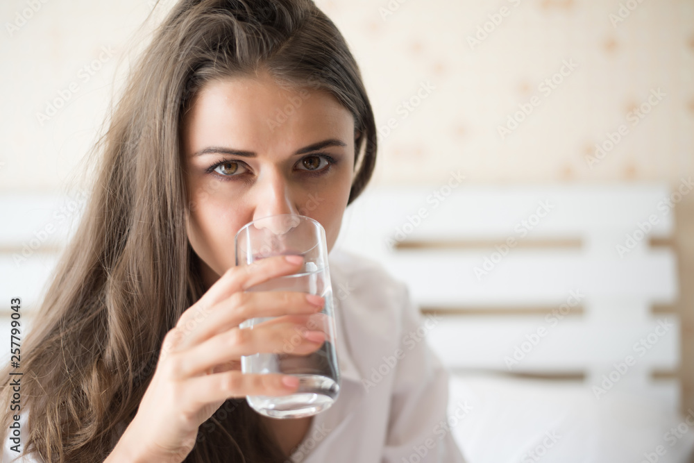 Beautiful woman drinking fresh water in the bed at the morning Beautiful woman drinking fresh water in the bed at the morning
