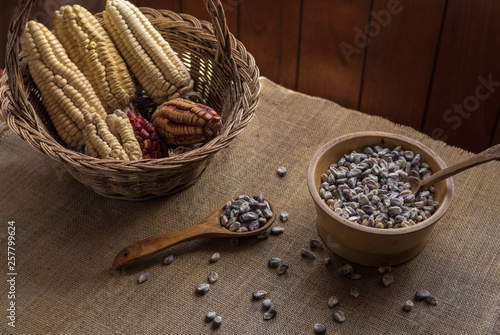 Mazorcas de maíz en canasta y granos de maíz en cuenco de madera