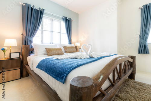 bedroom of the house or home with cozy bed , swan towel , high raised ceiling and blue blanket , interior design real estate 