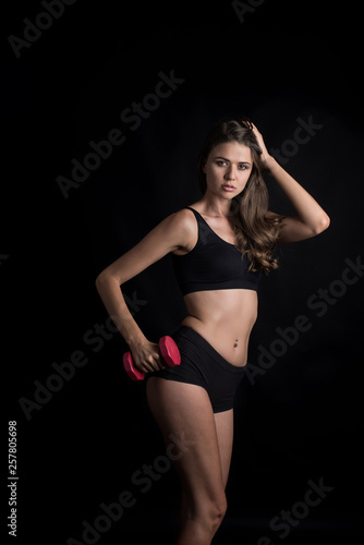 Portrait of young beautiful woman making physical exercises with dumbbells © Johnstocker