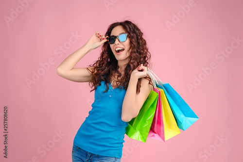 Attractive brunette girl with shopping bags from the mall and sunglasses smiling