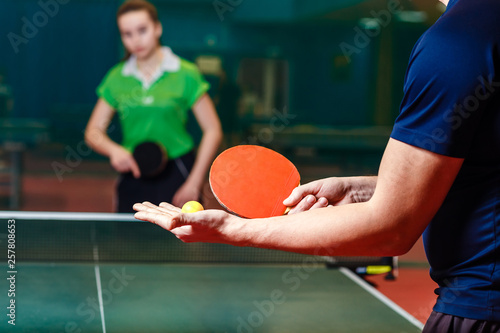 the coach teaches a teenage girl to play table tennis. Filing the ball in ping pong