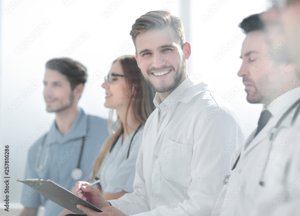 Close up of smiling doctor sitting with his team Close up of smiling doctor sitting with his team
