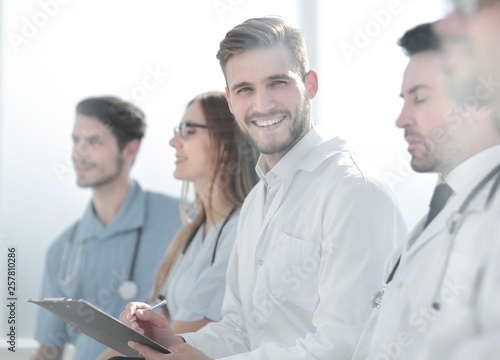 Close up of smiling doctor sitting with his team