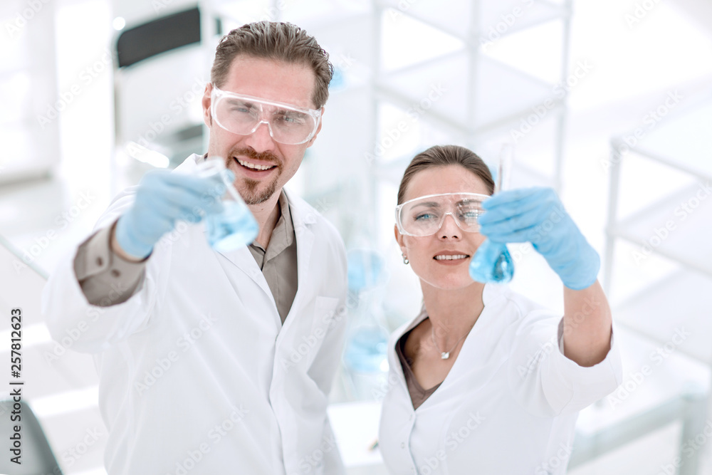 scientist and assistant with tubes, standing in the laboratory scientist and assistant with tubes, standing in the laboratory