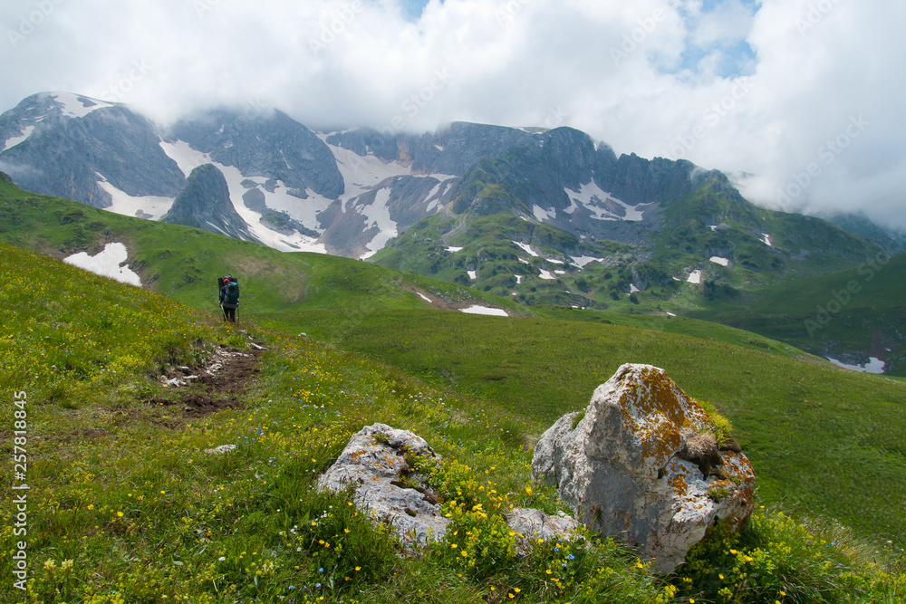 Tourists walk along the path in the mountains of the North Caucasus. Tourists walk along the path in the mountains of the North Caucasus.