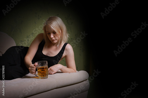 drunk woman alone in the room. Woman drinking beer and lying on the bed