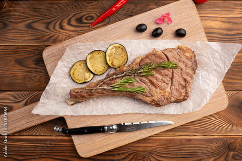 Grilled steak with lemon on a board on a wooden background