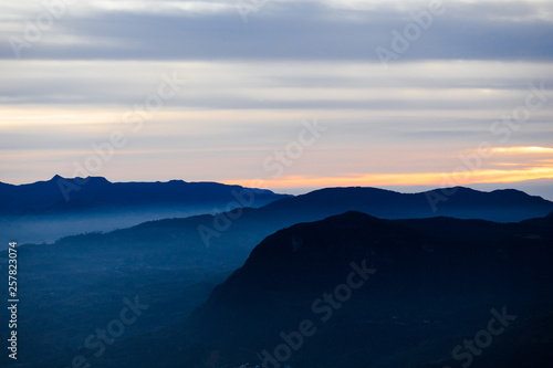 Blue landscape with mountains and morning fog. Cloudy sunrice