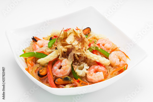 Salad with shrimps in a plate on a white background