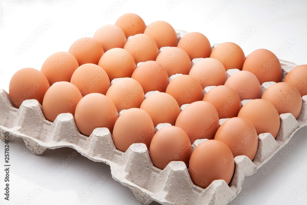 A tray of yellow homemade chicken eggs on a white background. A tray of yellow homemade chicken eggs on a white background.