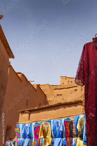 Colorful dresses and fabrics in shops of Ait Benhaddou ancient village in Morocco © Ilias Kouroudis