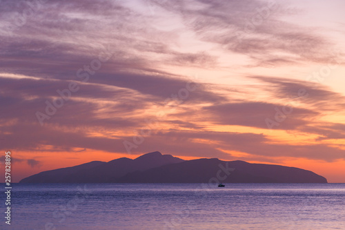 View of Hydra island against colorful morning sky from Spetses  Greece. 