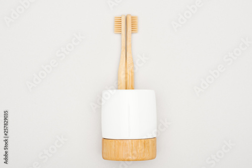 bamboo toothbrushes in stand on grey background