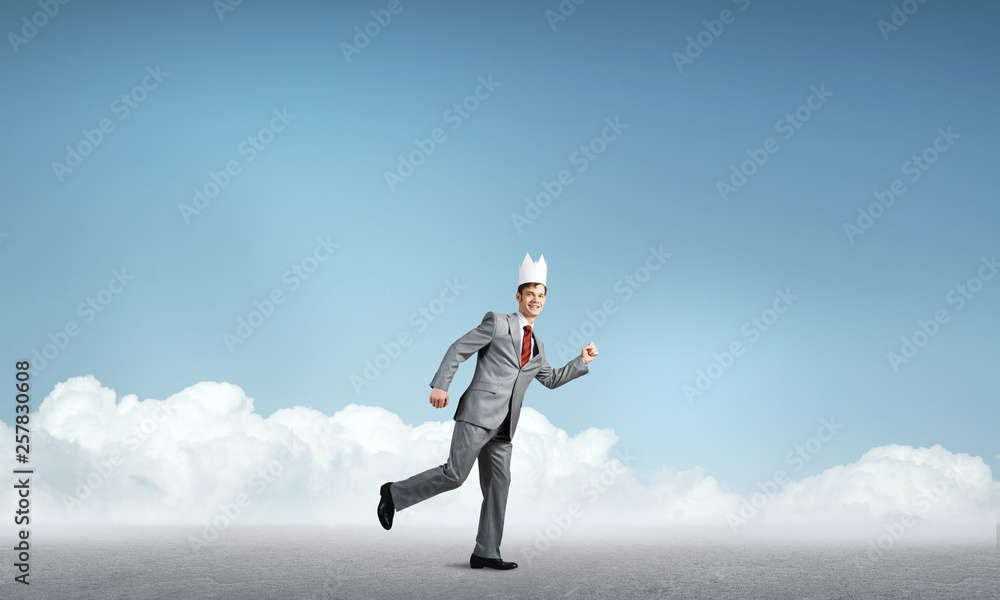 King businessman in elegant suit running and blue cityscape silhouette at background King businessman in elegant suit running and blue cityscape silhouette at background