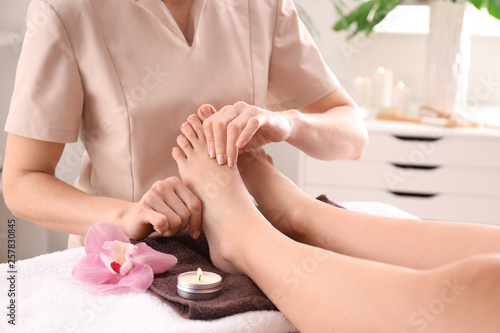 Young woman receiving feet massage in spa salon