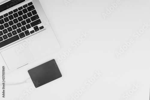 Laptop keyboard, storage drive or hard disk on yellow background with selective focus, crop fragment, business, backup, copy space concept. Black and White