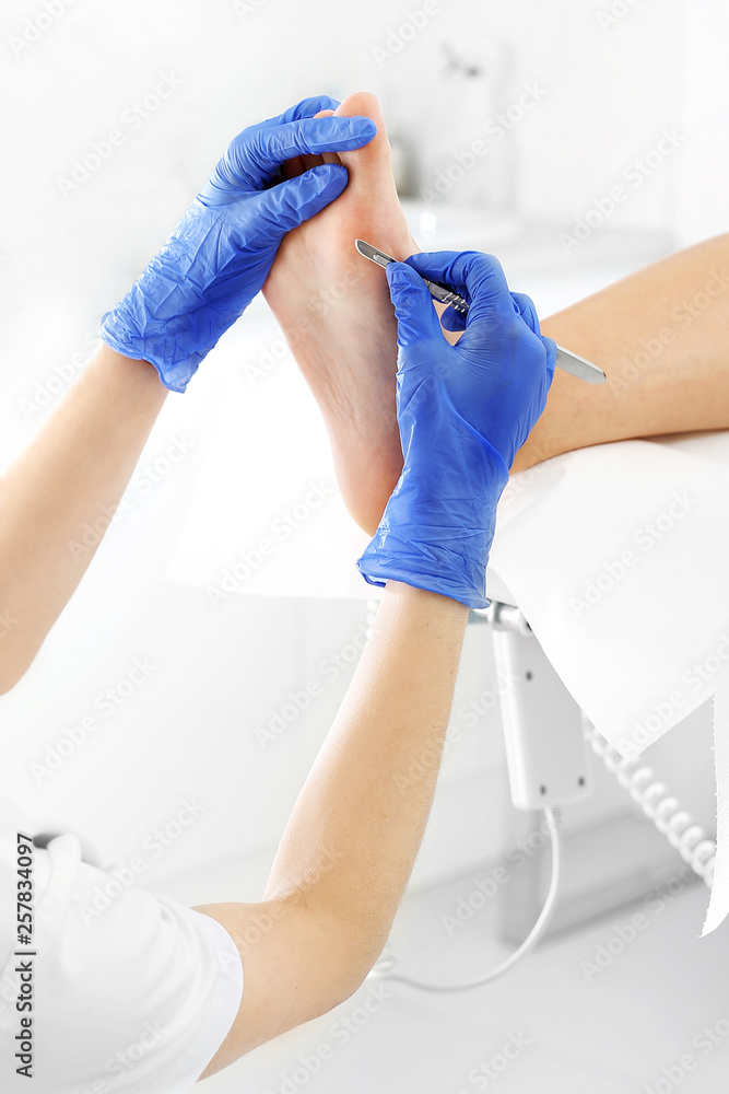 Podiatry. Removing calluses with a scalpel at the beautician. Podiatry. Removing calluses with a scalpel at the beautician.