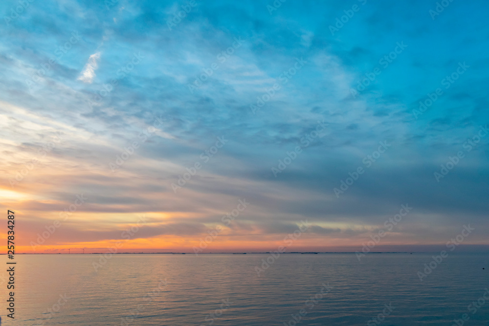 The colorful sky at sunset is reflected in the sea.  Seascape with sunset. 