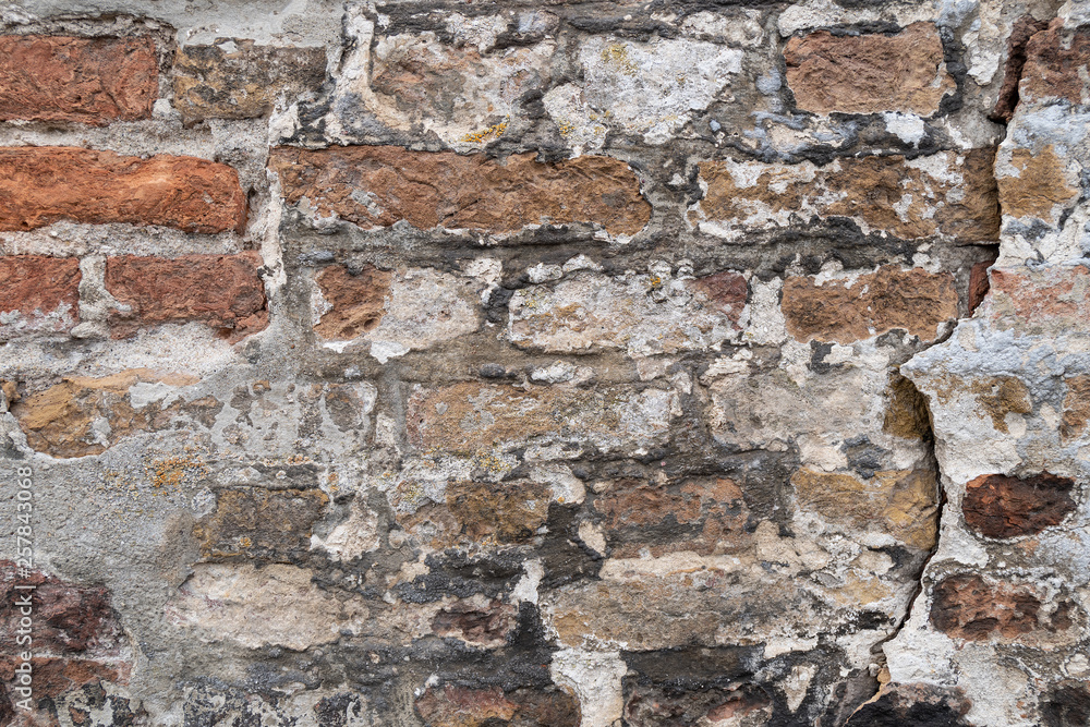 Old stone wall with broken plaster as a background Old stone wall with broken plaster as a background