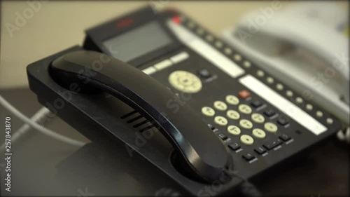Woman hangs up the old wired phone with buttons, close-up
