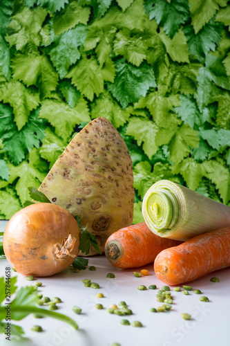 vegetables, ingredients for Dutch traditional food snert, split peas soup. White table, green leaves background photo