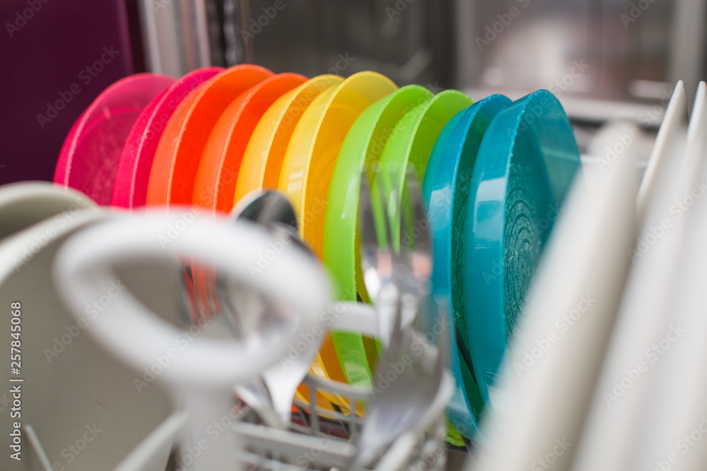 Colorful plastic dishes in a clean dishwasher