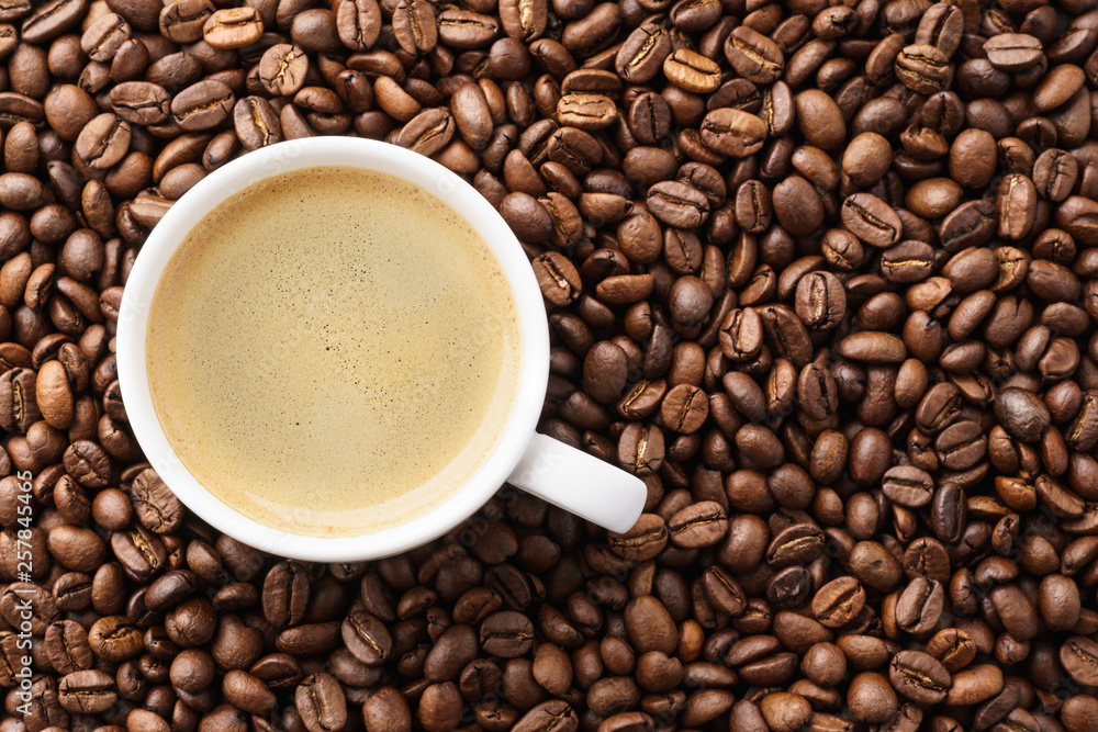 Coffee cup on roasted coffee beans. Top view. Coffee cup on roasted coffee beans. Top view.