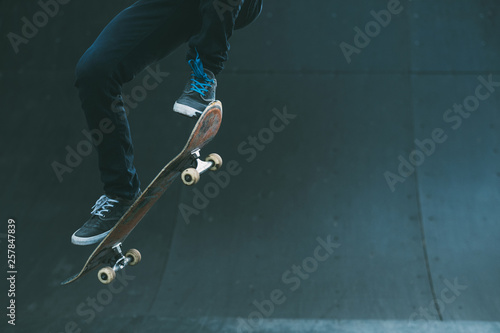Urban skater in action. Ollie trick. Skate park ramp. City area. Man on skateboard jumping. Copy space for text. photo