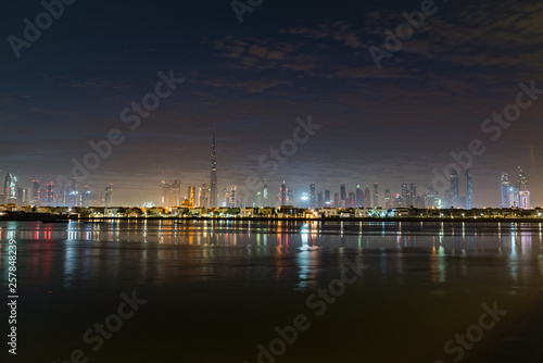 Night or dusk in Dubai. Dawn over Burj Khalifa. Nightly Dubai downtown. View from sea to Dubai quay