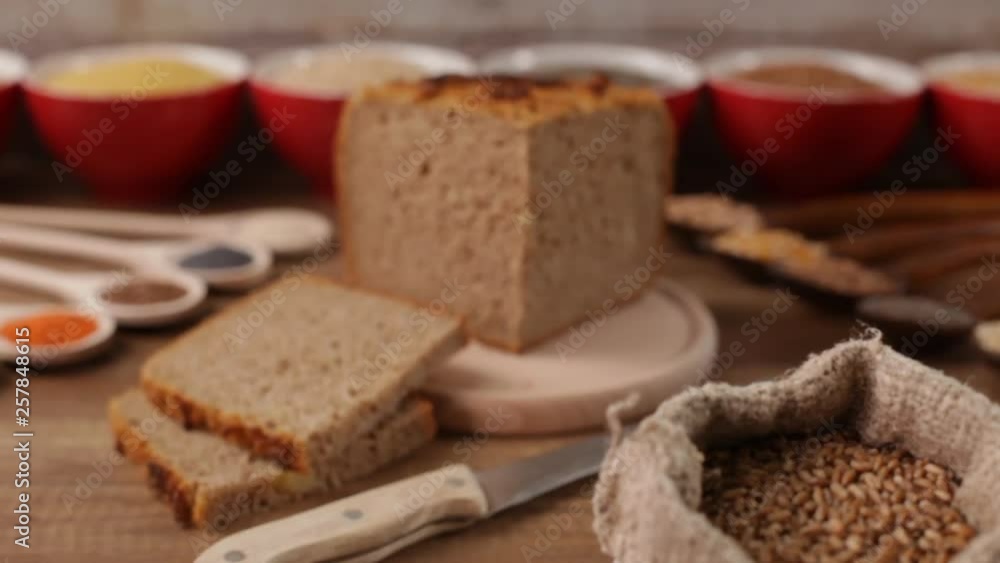Whole food concept - wholemeal bread in center with various seeds and grains around. Camera push in, refocus from wheat to bread loaf. Whole food concept - wholemeal bread in center with various seeds and grains around. Camera push in, refocus from wheat to bread loaf.