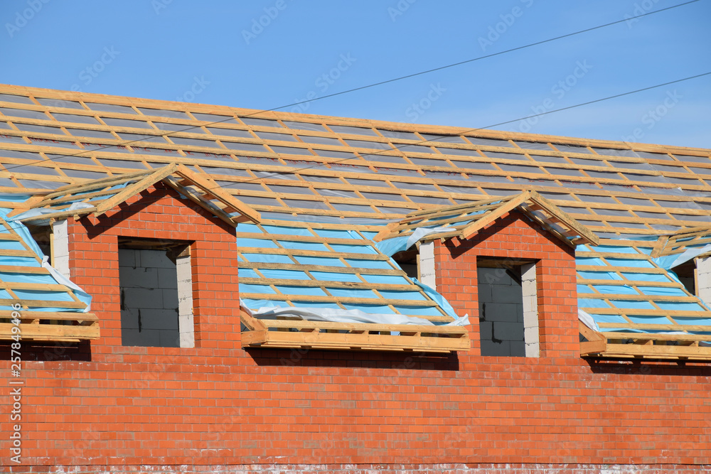 Construction of the roof of a new house. Wooden bars and vapor barrier