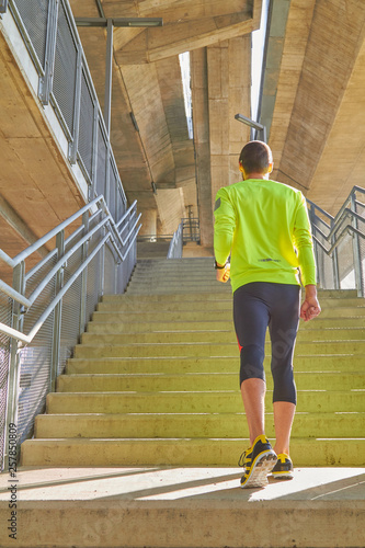 Sportsman working out / jogging on a big city urban bridge.