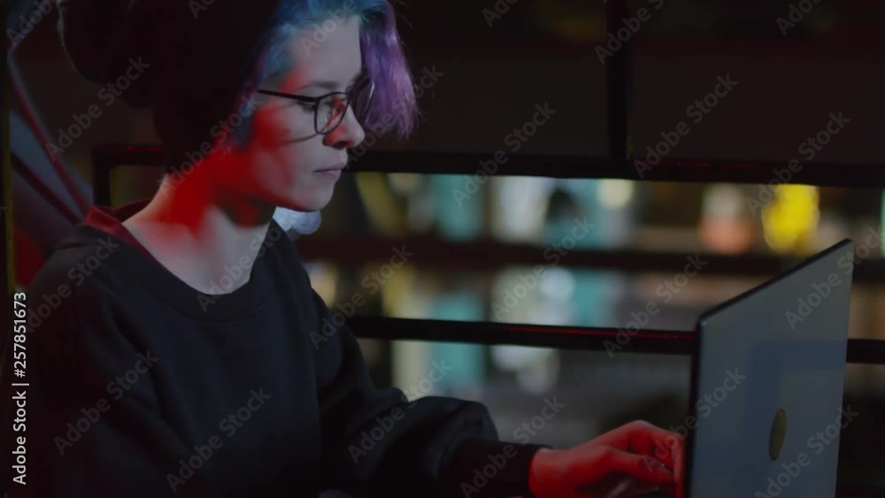 Tilt down of young woman-hipster sitting at table in restaurant and typing on laptop keyboard Tilt down of young woman-hipster sitting at table in restaurant and typing on laptop keyboard