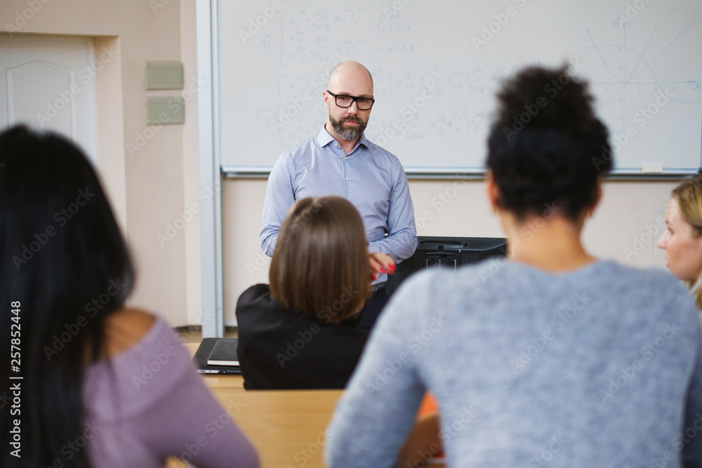 Lecturer and multinational group of students in an auditorium Lecturer and multinational group of students in an auditorium